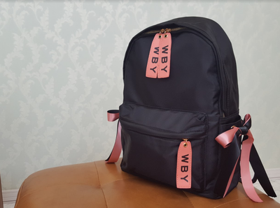 サイドのリボンがアクセント ピンク 黒のナイロンリュック Base Mag