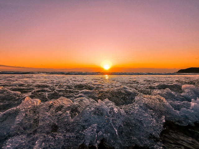 白浜海岸の水平線に浮かぶ朝日ときらめく波頭 Photosmilejp
