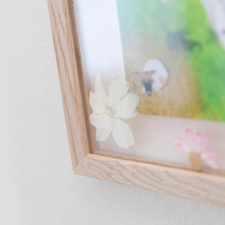 イラストに描かれている花の押し花が一緒に額装されています