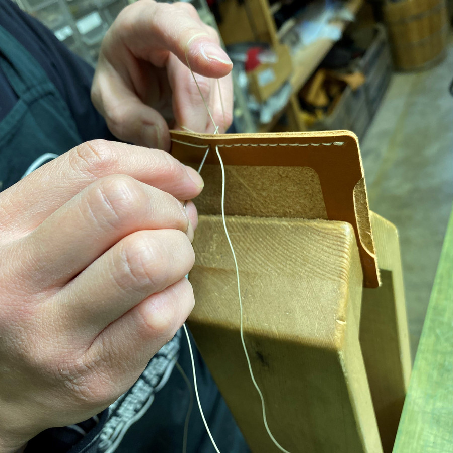 ロウ引きした手縫い糸で縫う。
