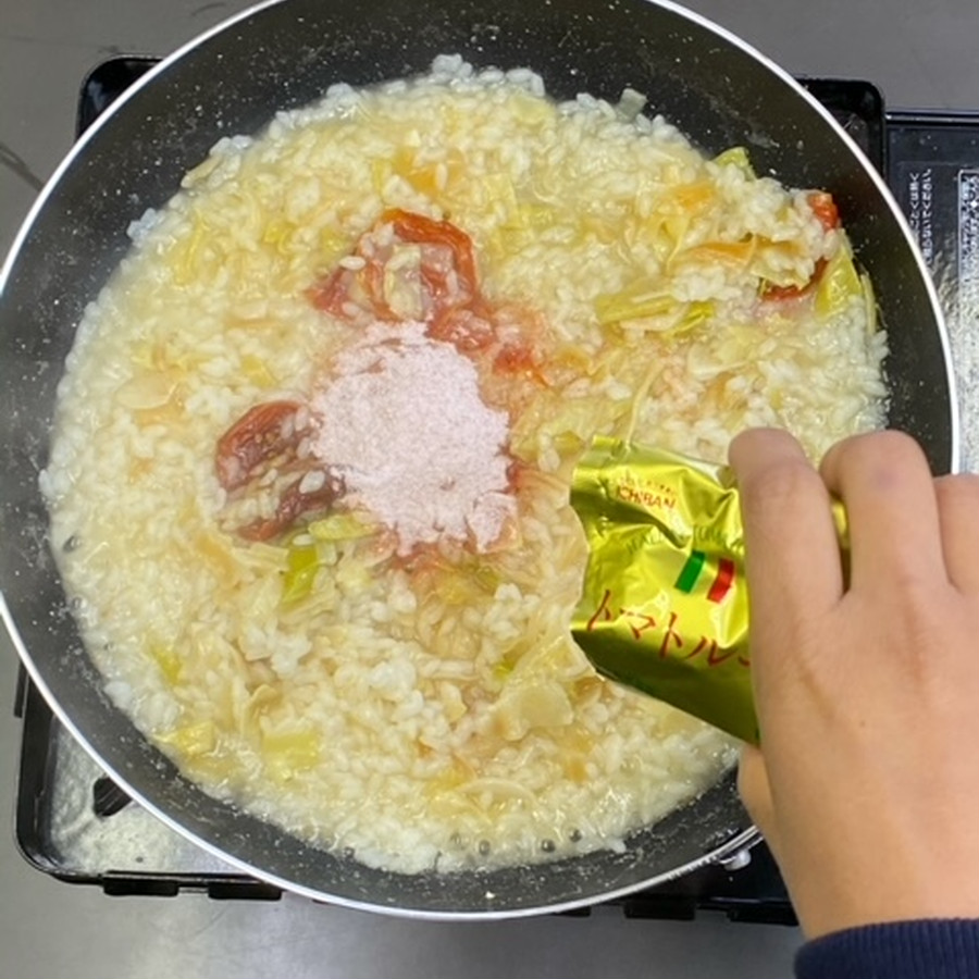 米が硬ければ水を足し、中火で更に煮込みます。良い硬さになったら、トマトソースを入れて混ぜ合わせます。